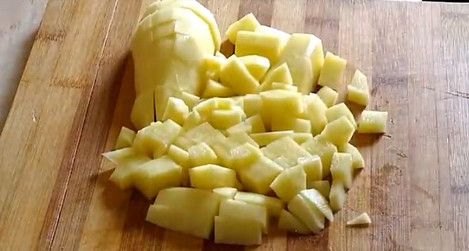 Очистите и нарежьте кубиками картофель для горохового супа.