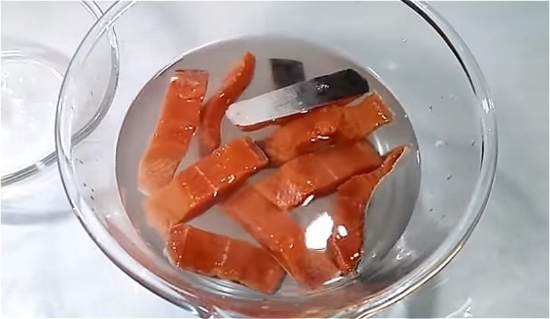 Приготовьте рассол и положите в него кусочки горбуши.