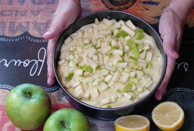 Форма для выпечки с тестом и яблоками.